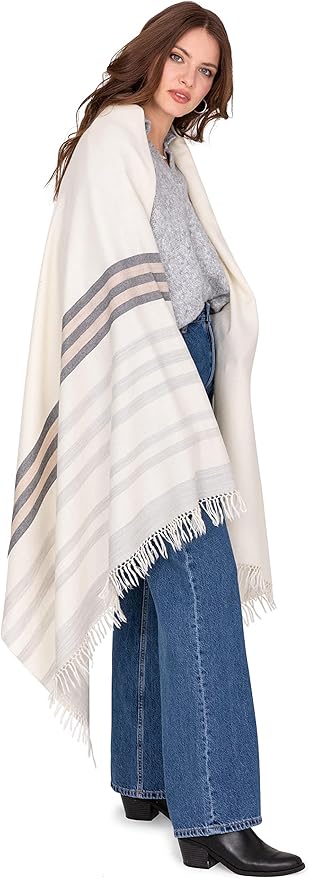 Lightweight shawl-style blanket wrap in neutral fabric, styled both as a cozy sofa throw and as a wearable autumn layer